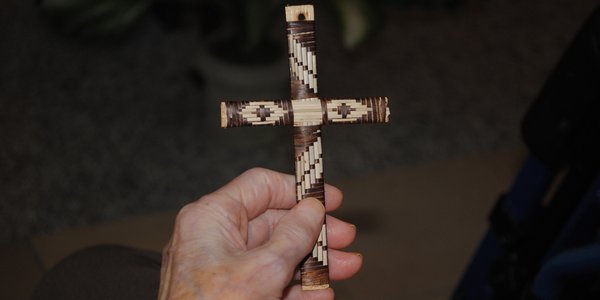 Schlichtes Kreuz in den Händen einer Seniorin.