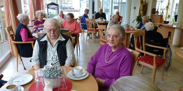 Bewohnerinnen genießen Kaffee und Kuchen in der Cafeteria.